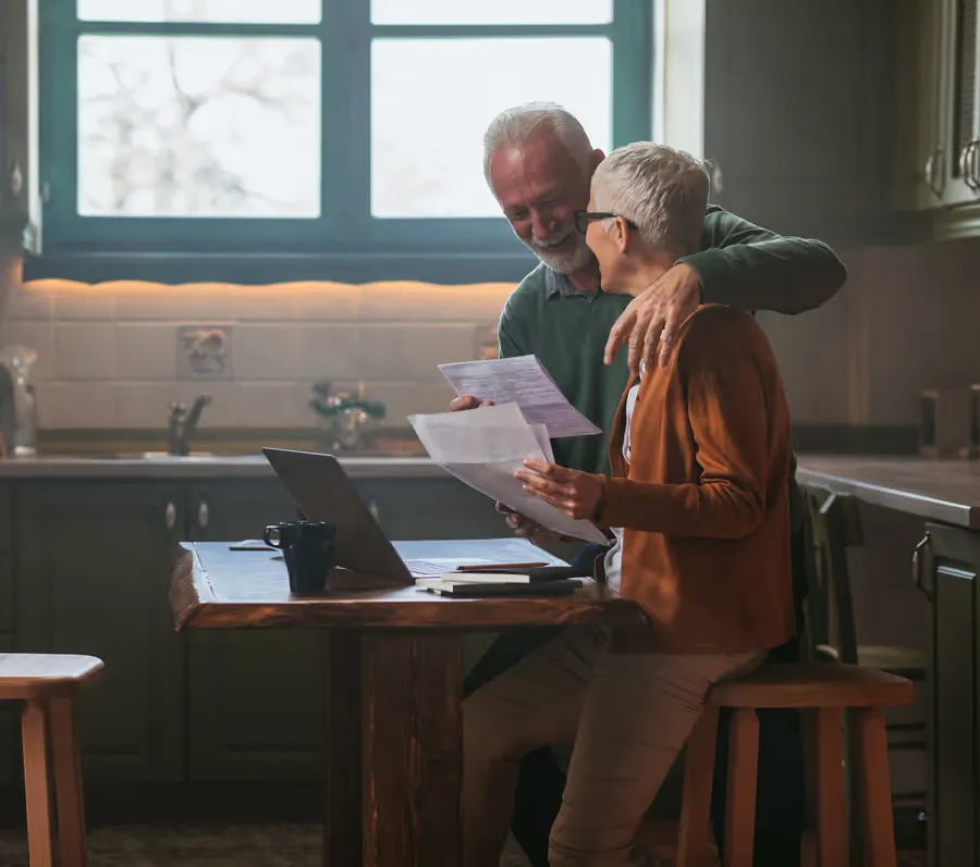 Older couple sitting across from a financial advisor at a table, relaxed and engaged in conversation.